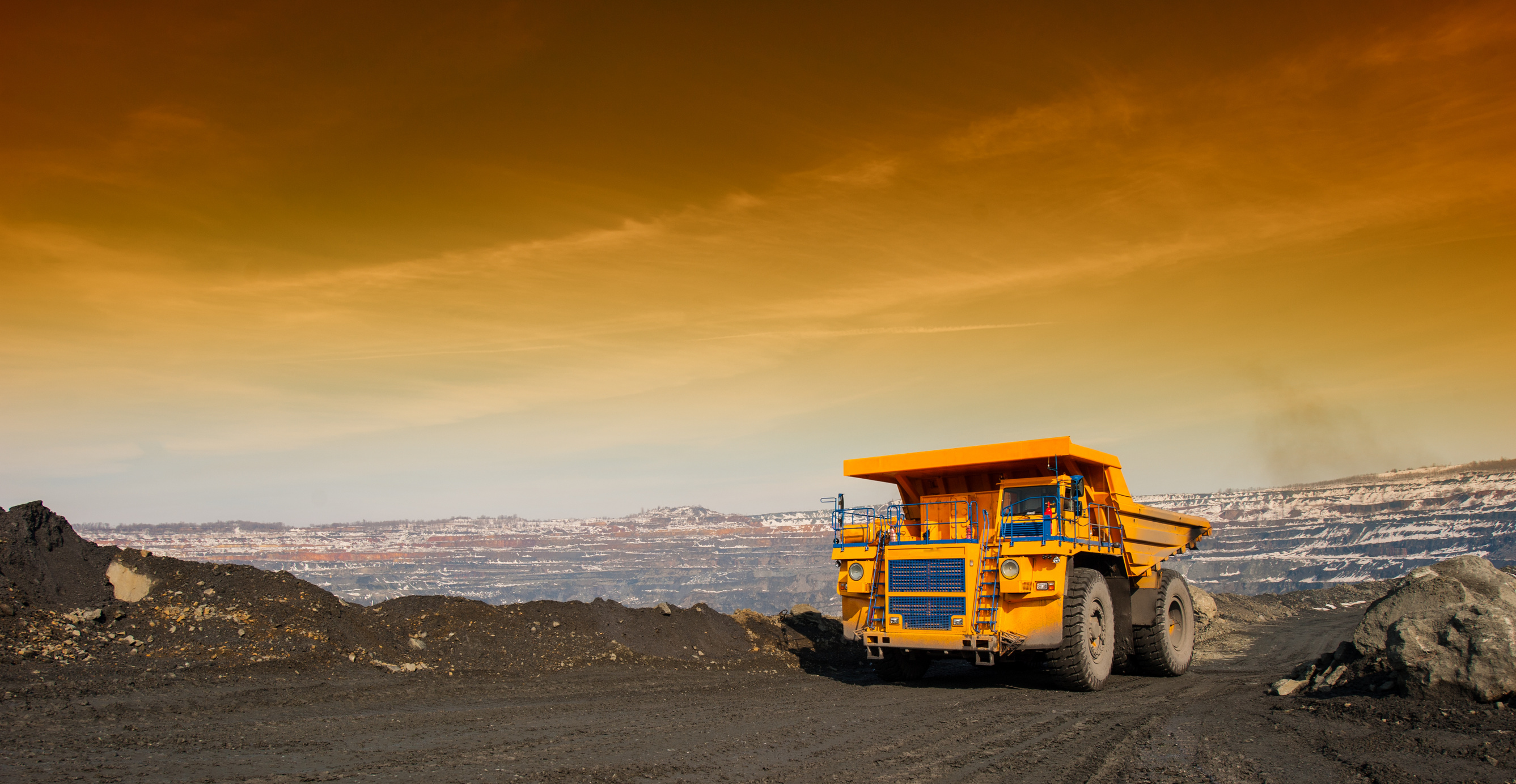 yellow mining truck driving through dirt